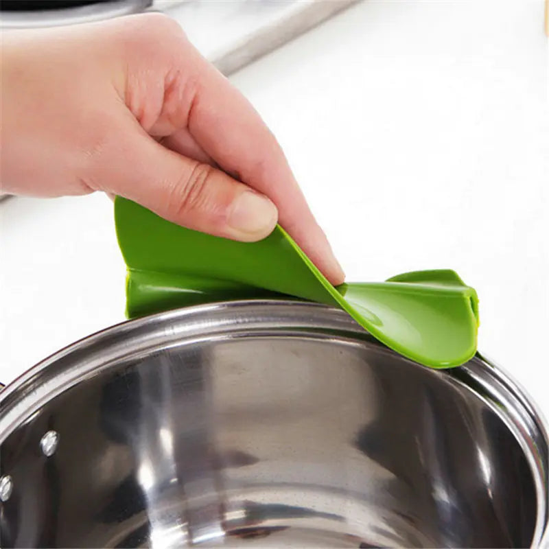  Close-up of the clip-on silicone pouring spout showing its fit on a kitchen pot.
