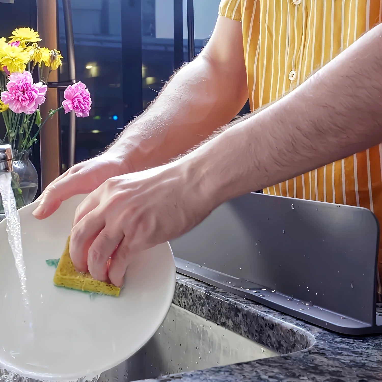Splash guard blocking water splashes during dishwashing.
